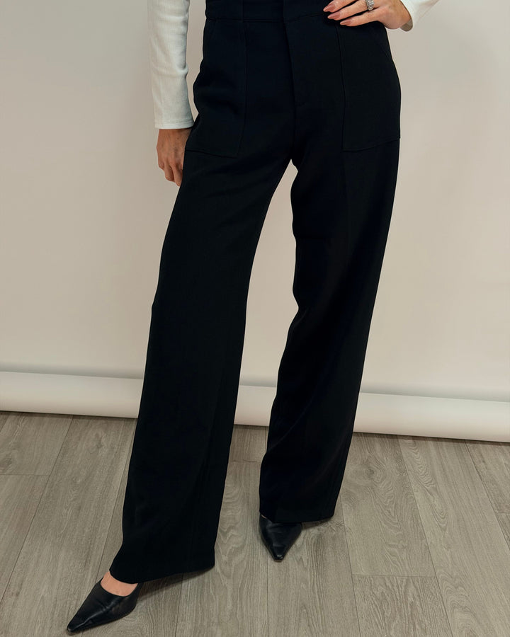 Person wearing black wide-leg pants against a plain background