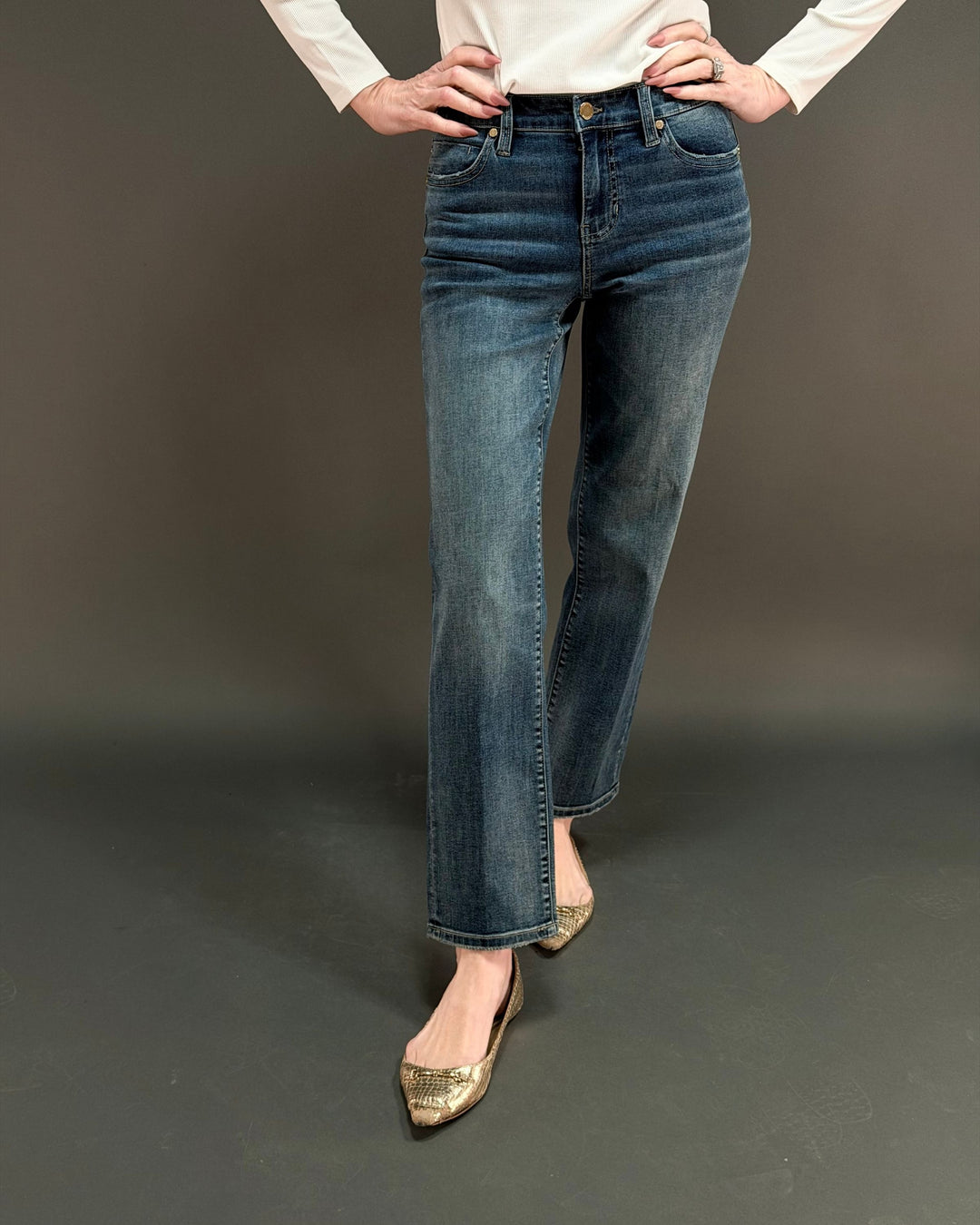 woman wearing straight leg jean in front of a gray background