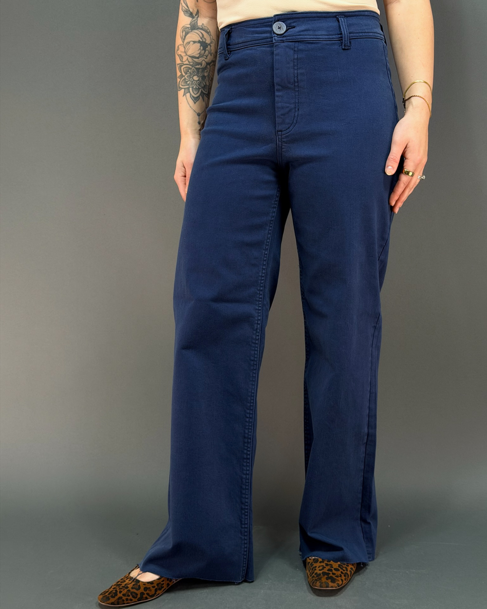 woman wearing navy wide leg pant in front of a gray background