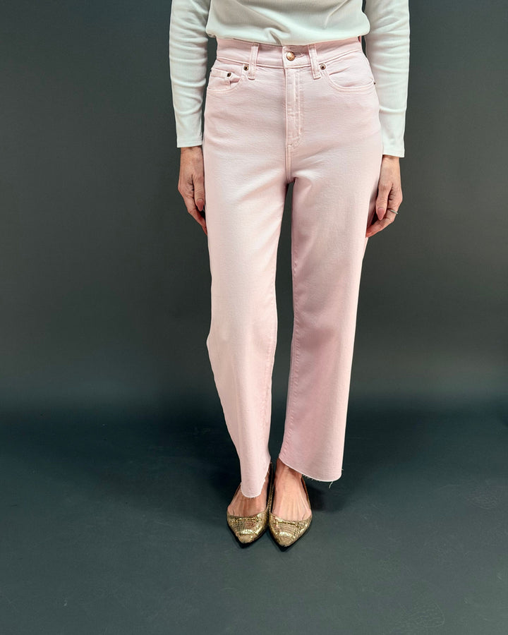 woman wearing pink wide leg jean in front of gray background