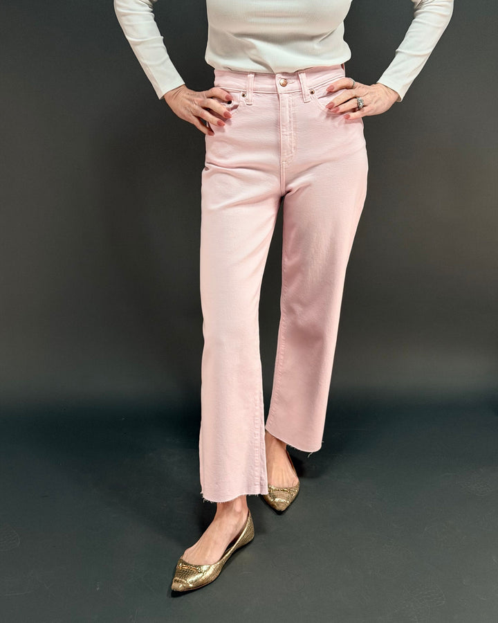 woman wearing pink wide leg jean in front of gray background
